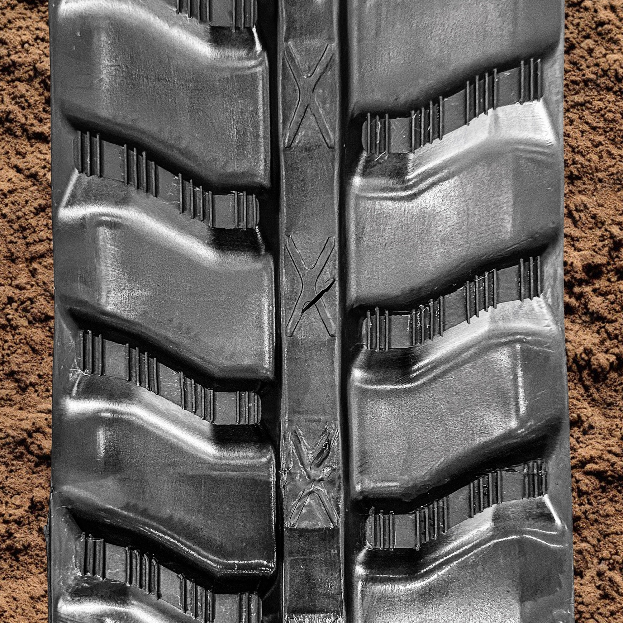 Front view of an S-lug rubber track tread pattern, highlighting its design for traction and durability on skid steers and mini excavators.